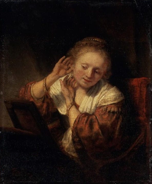 Jeune femme essayant des boucles d’oreilles – Rembrandt van Rijn Rembrandt van Rijn 70x85